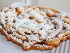 powdered sugar covered pastry sitting on top of a white plate