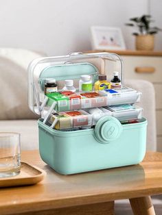 an icebox filled with lots of food on top of a wooden table next to a glass