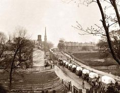 an old black and white photo of horses pulling wagons