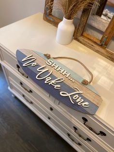 a wooden sign that says, we love you in white and blue on top of a dresser