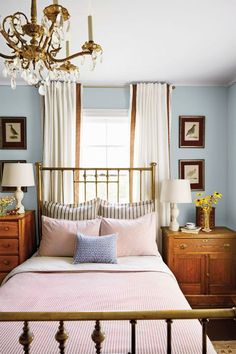 a bed room with a neatly made bed and a chandelier