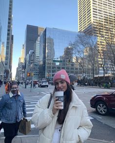 a woman taking a selfie with her cell phone on the street in new york city