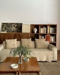 a living room with a couch, coffee table and bookshelf in the background