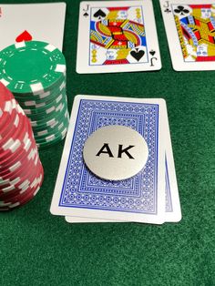 poker chips and cards on a green table with the letters ak in front of them