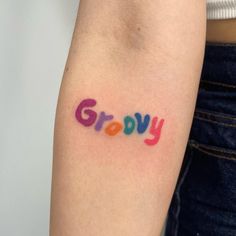 a woman's arm with the word grooy written in multicolored ink