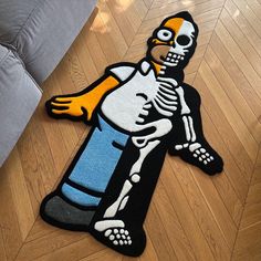 a rug with a cartoon skeleton holding a blue cup on it's back and feet