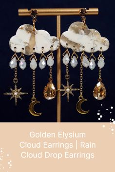 the golden elyum cloud earrings are hanging from chains