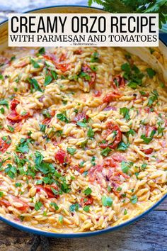 creamy orzo recipe with parmesan and tomatoes in a blue dish on a wooden table