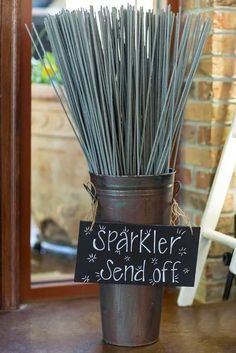 a vase filled with sticks and a sign that says sparkler send - off on it