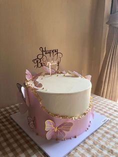 a birthday cake decorated with butterflies on a table