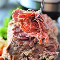 a fork is stuck into some meat and vegetables