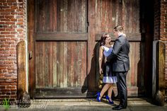 a man and woman standing in front of a wooden door