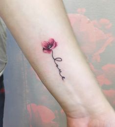 a small pink flower with the word love tattooed on it's left arm and wrist