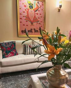 a vase filled with yellow flowers sitting on top of a table next to a couch