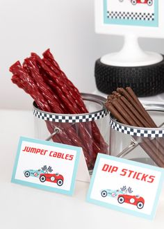 a table topped with two buckets filled with different types of sticks and stick tags