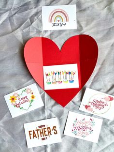 a paper heart with some cards attached to it, and the words happy father's day written on them