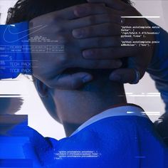 a man covering his face with his hands while standing in front of a computer screen