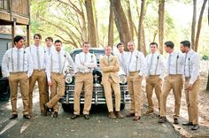 a group of men standing next to each other in front of a car