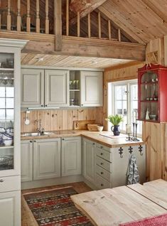 a kitchen with wooden floors and white cabinets in it's center area, along with a red refrigerator freezer