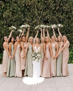 a group of women standing next to each other holding bouquets in front of them