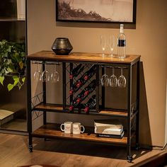 a table with wine glasses and bottles on it in front of a framed photo above