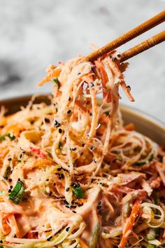 chopsticks picking up noodles from a bowl