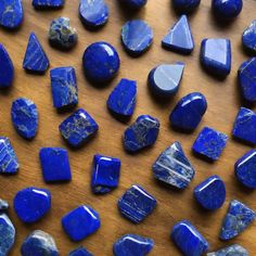 many blue rocks are laying on a wooden surface