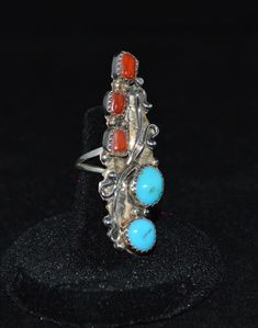 Truly unique vintage rings. We have three available. Each ring has two 8 mm turquoise round gems and three 5 mm rectangle red coral shells. Each of the three rings are bezel set in  1 3/4 inch long ring with scrolls and dots.  Ring sizes are: 5 3/4 and 8.  This ring is truly a statement ring that is sure to bring attention. All natural gems and sterling silver. Navajo handmade Unique Red Multi-stone Turquoise Ring, Southwestern Style Red Ring Jewelry, Red Bohemian Multi-stone Rings, Bohemian Red Multi-stone Ring, Adjustable Southwestern Red Rings, Southwestern Style Red Turquoise Ring, Adjustable Southwestern Style Red Rings, Red Southwestern Multi-stone Rings, Southwestern Multi-stone Red Ring