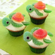 three cupcakes with white frosting and red flowers on them, sitting on top of a green napkin