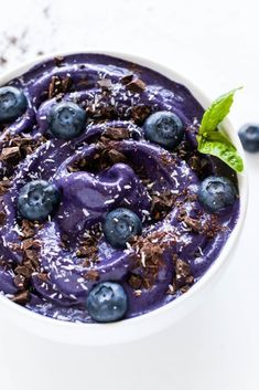 a white bowl filled with blueberries and chocolate