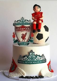 there is a cake that has a soccer ball on it and a figurine sitting on top