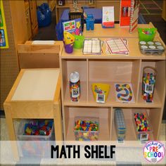 a wooden shelf filled with lots of toys and building blocks next to a sign that says math shelf