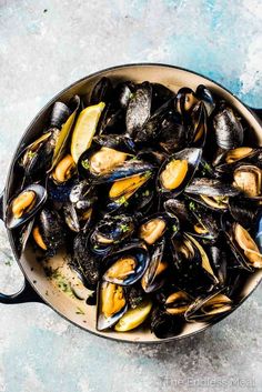 a pan full of mussels with the title how to cook mussels and mussels in white wine recipe