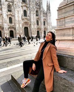 a woman sitting on steps in front of a cathedral