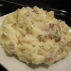 a white plate topped with mashed potatoes covered in green sprinkles