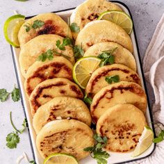 some food that is on a plate with limes and cilantro in the background