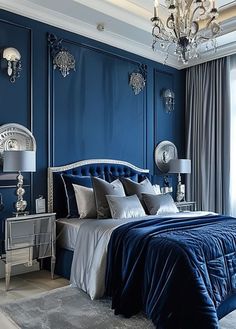 a bedroom decorated in blue and silver with a chandelier hanging from the ceiling