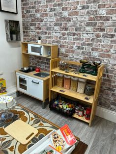 a small kitchen with an oven, microwave and other items on the table in front of a brick wall