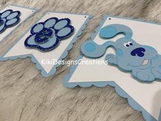 some blue and white paper cut outs with dogs on them, one has a dog's head