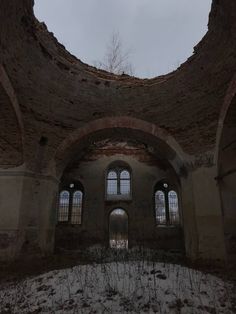 the inside of an old building with windows and snow on the ground in front of it