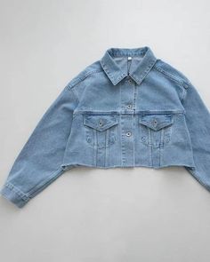 Classic medium blue denim jacket with cropped raw edged hem- Oversize cut- Pointed collar - Dropped shoulders- Button front- Front flap pockets- Buttoned cuffs- Cotton 100%- Length 18", Bust 47", Sleeve 30.5" - Dry clean- Imported Denim Blue Cotton Button-up Jacket, Unstructured Denim Button-up Jacket, Oversized Collared Single-breasted Denim Jacket, Unstructured Cotton Denim Button-up Jacket, Crop Denim Jacket, Medium Wash Button-up Denim Cropped Jacket, Blue Denim Jacket, Cropped Denim Jacket, Black Blazers