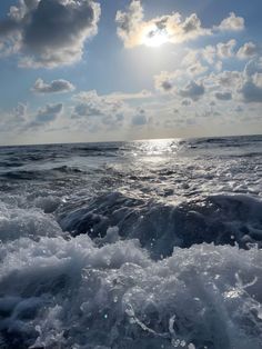 the sun shines through clouds over rough water