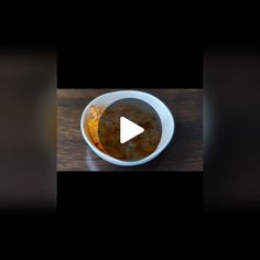 a white bowl filled with food on top of a wooden table