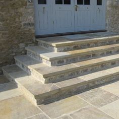 stone steps lead up to the front door of a house