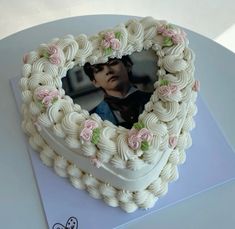 a heart shaped cake with a photo in the middle