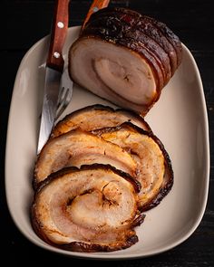 sliced ham on a plate with a knife and fork