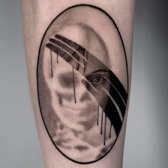 a man's leg with a black and white tattoo design on it, featuring an eye