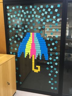 an office cubicle decorated with sticky notes and a colorful umbrella on the glass door