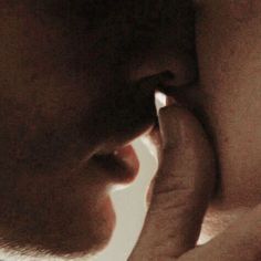 a close up of a person kissing another persons face with his hand on his cheek