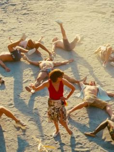 a group of people laying on top of a sandy beach